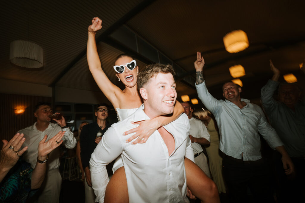 Bride and groom Aimee and Riley sharing a relaxed and emotional moment during their NSW wedding surrounded by natural scenery and soft romantic light.