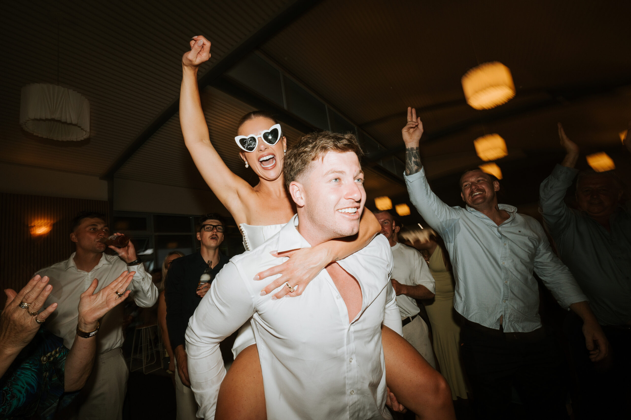 Bride and groom Aimee and Riley sharing a relaxed and emotional moment during their NSW wedding surrounded by natural scenery and soft romantic light.